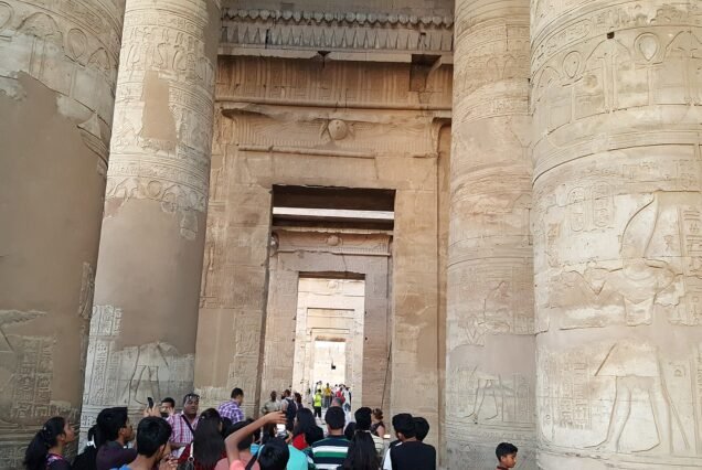 Le colonne scolpite della sala interna di Kom Ombo, con i portali allineati verso il santuario e i visitatori in primo piano