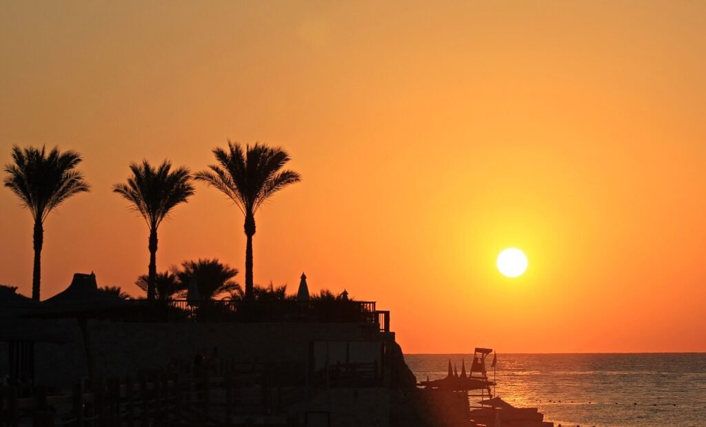 Il sole sorge sul Mar Rosso fra le palme di un resort