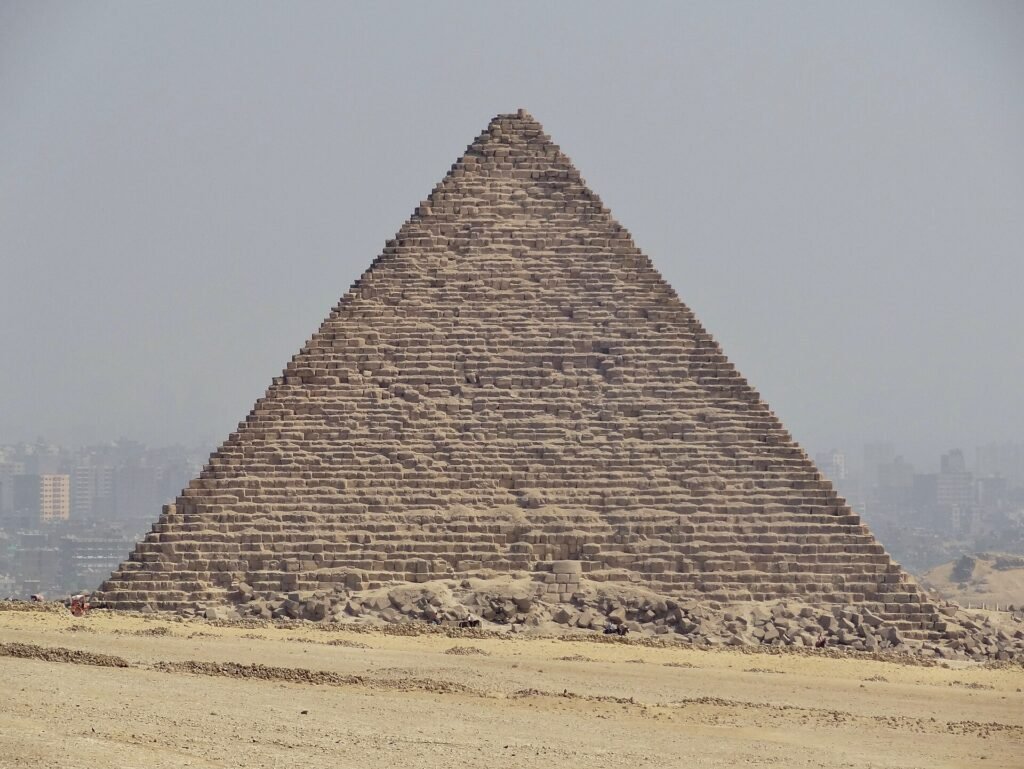 Una piramide di Giza con il profilo del Cairo sullo sfondo: la città arriva fino al sito