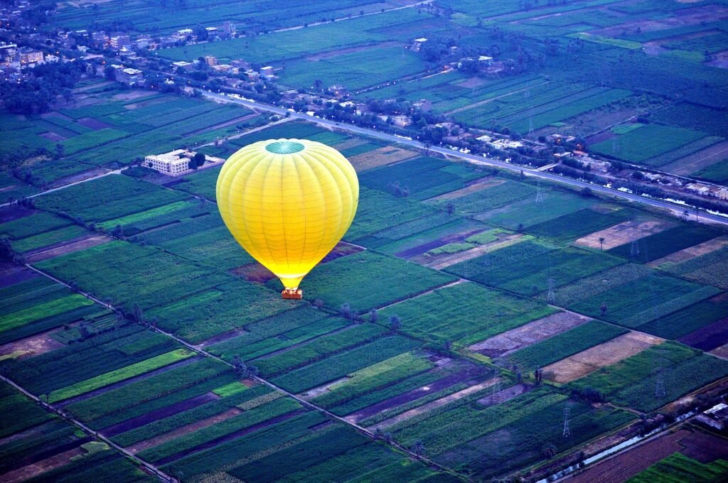 Una mongolfiera sopra i campi coltivati della riva ovest di Luxor alle prime luci