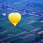 Una mongolfiera sopra i campi coltivati della riva ovest di Luxor alle prime luci