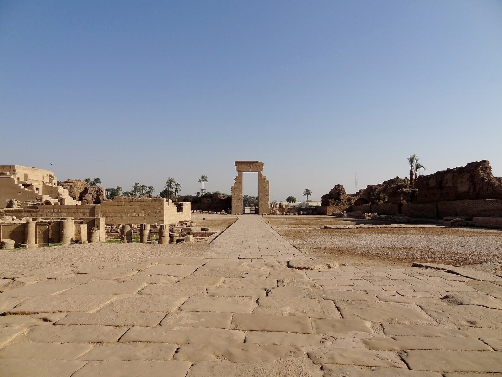 Il piazzale lastricato del complesso di Dendera verso il portale in pietra, con i resti delle costruzioni ai lati
