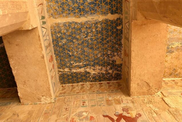 Il soffitto blu dipinto con stelle dorate in una sala interna del tempio di Hatshepsut, con l'architrave geroglifico ancora colorato