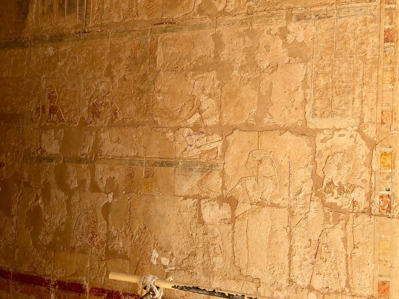 Una parete in rilievo molto erosa all'interno del tempio di Hatshepsut, con tracce di colore lungo le fasce decorative