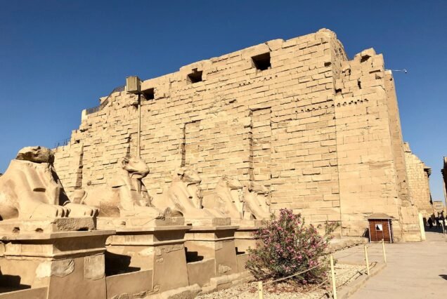 Il viale delle sfingi con testa di ariete e il primo pilone monumentale del tempio di Karnak