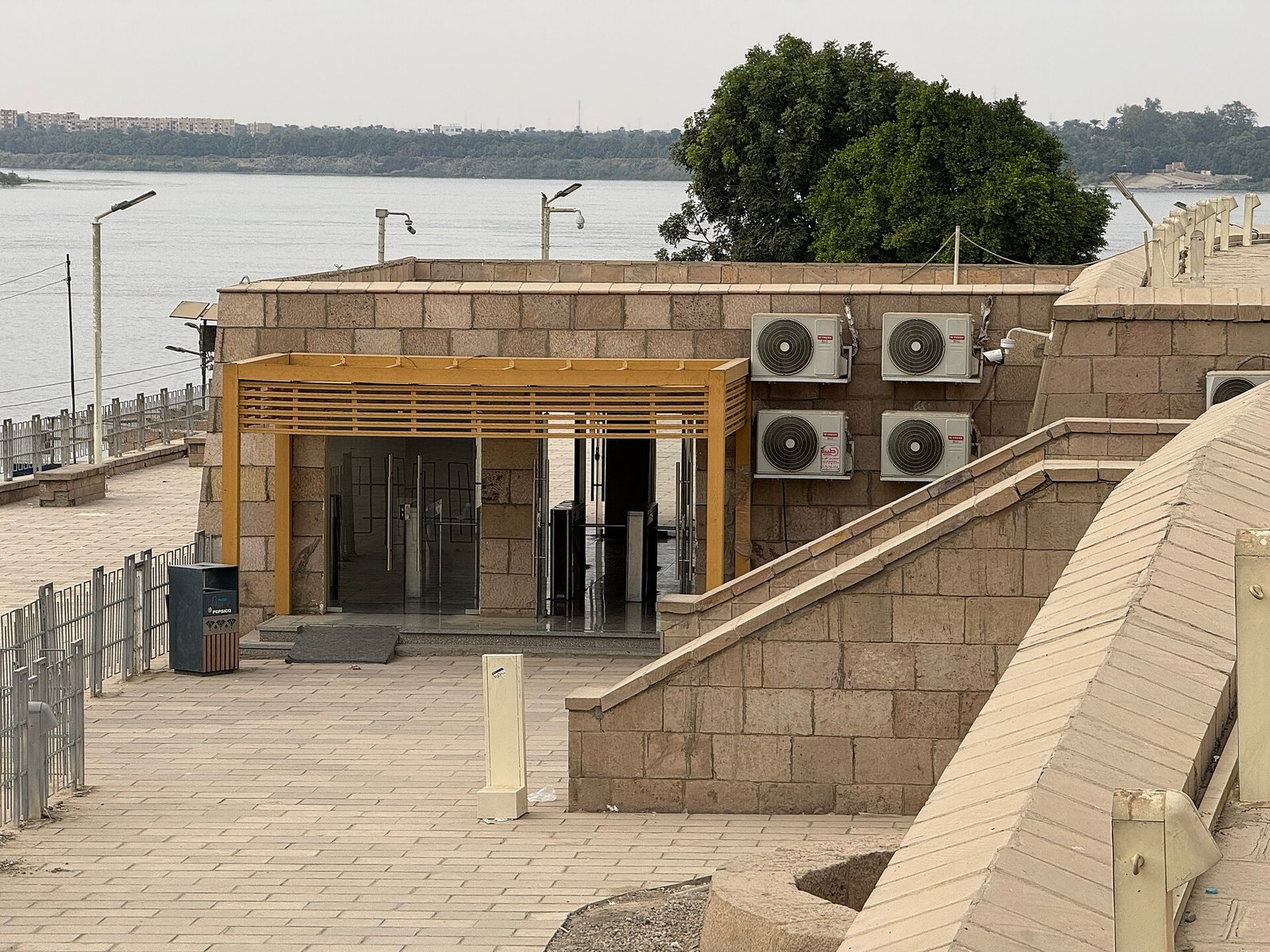 L'ingresso moderno dell'area archeologica di Kom Ombo, con la biglietteria in blocchi di pietra e il Nilo alle spalle