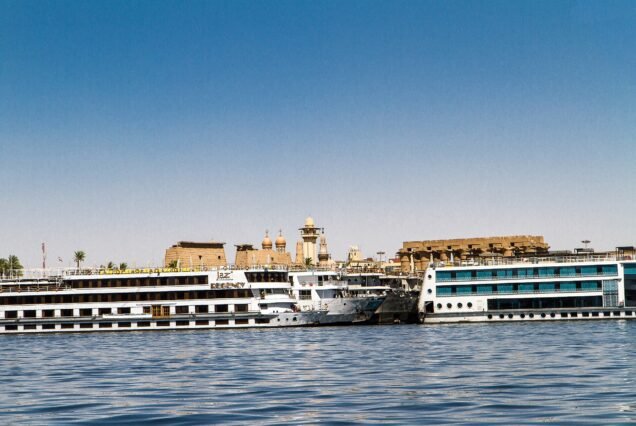 Le navi da crociera ormeggiate davanti al tempio di Luxor, che si intravede sulla riva alle loro spalle