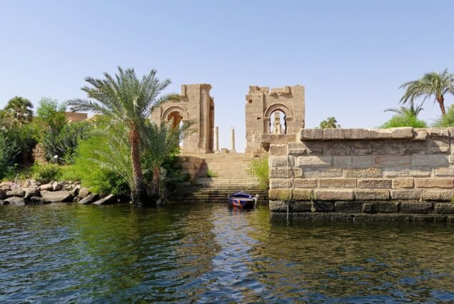 L'approdo di Philae visto dalla barca, con la scalinata che sale dall'acqua e i resti del portale ad arco fra le palme