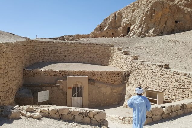 L'ingresso recintato di una tomba dei nobili a Luxor ovest, con il cancello metallico e la collina di roccia alle spalle