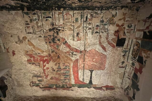 Una parete dipinta molto rovinata in una tomba della Valle delle Regine, con il soffitto stellato e ampie perdite di intonaco