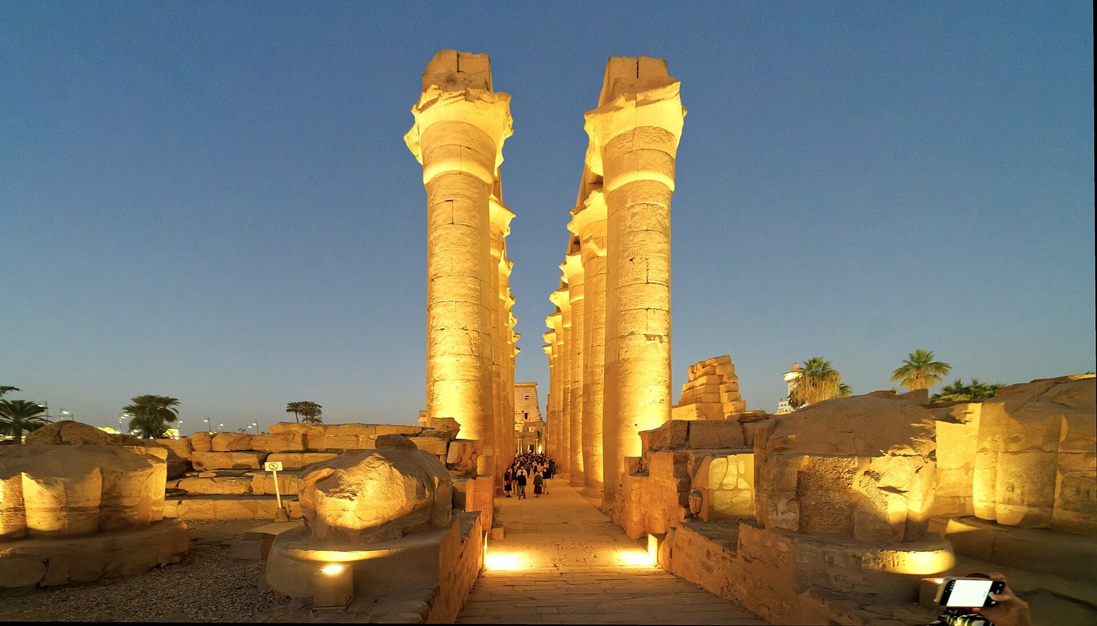 Il colonnato di Amenhotep III nel tempio di Luxor illuminato all'ora blu, con le due file di colonne monumentali che incorniciano l'asse processionale