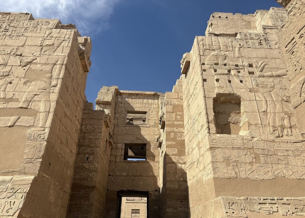 Il grande pilone d'ingresso di Medinet Habu visto dal basso, con i rilievi sulle due torri e il passaggio centrale