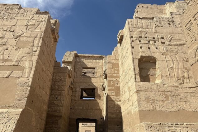 Il grande pilone d'ingresso di Medinet Habu visto dal basso, con i rilievi sulle due torri e il passaggio centrale