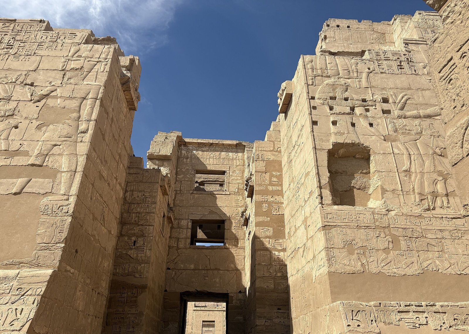 Il grande pilone d'ingresso di Medinet Habu visto dal basso, con i rilievi sulle due torri e il passaggio centrale