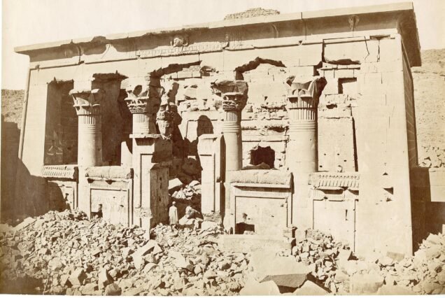 Fotografia storica in seppia del tempio di Kalabsha nel suo sito originario, in rovina e circondato da blocchi crollati