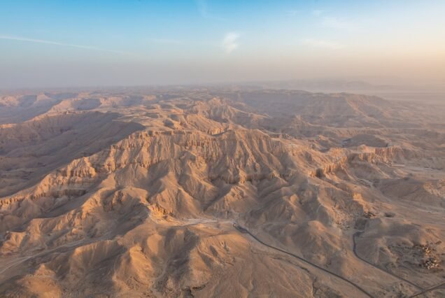 Veduta aerea al sole basso delle colline desertiche della riva ovest di Luxor, con i valloni che nascondono le tombe reali