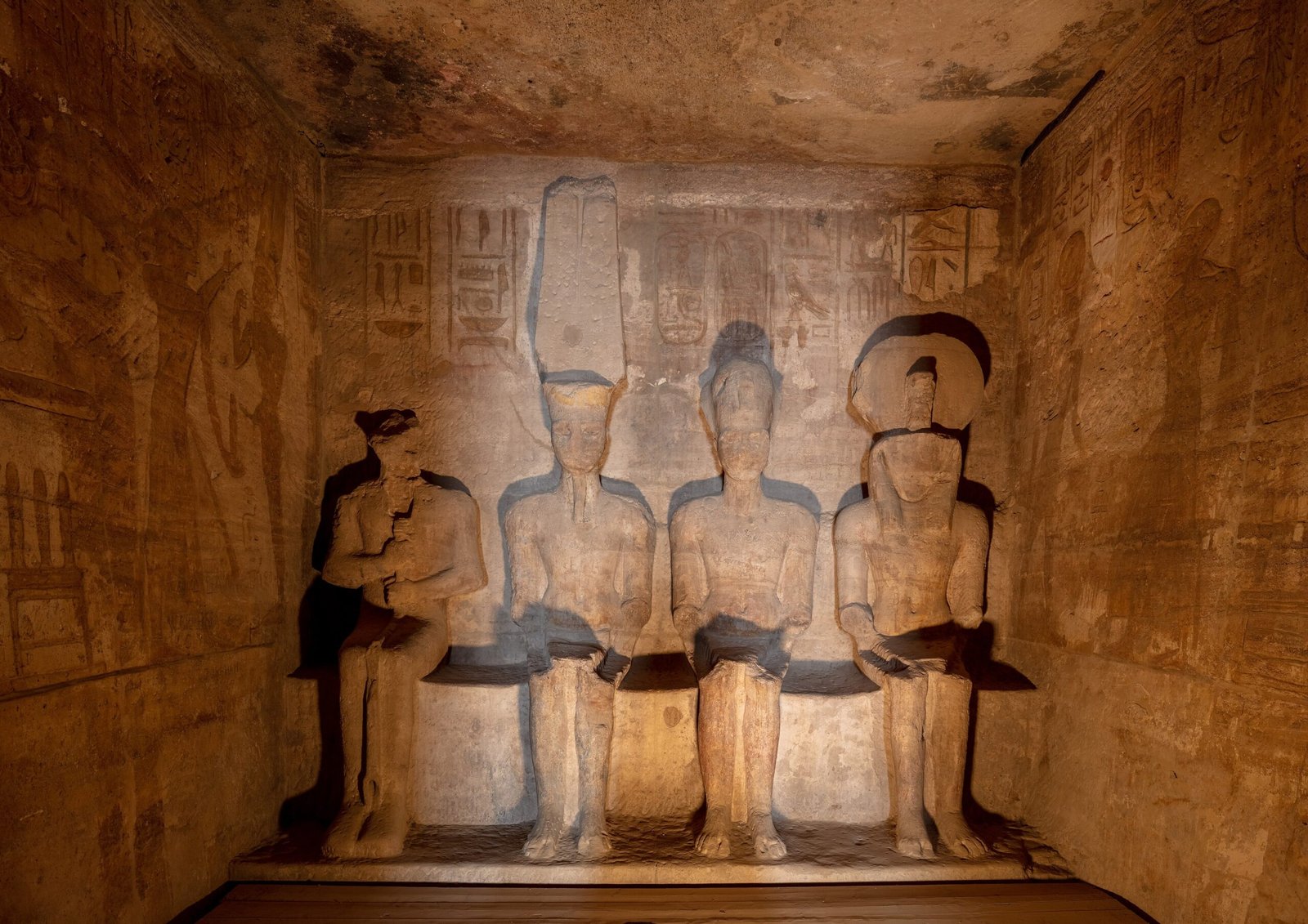 Le quattro statue sedute del santuario di Abu Simbel illuminate nella penombra della roccia