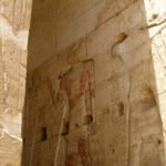 Parete di rilievi ad Abydos illuminata di taglio, con tracce di pittura rossa sulla figura regale