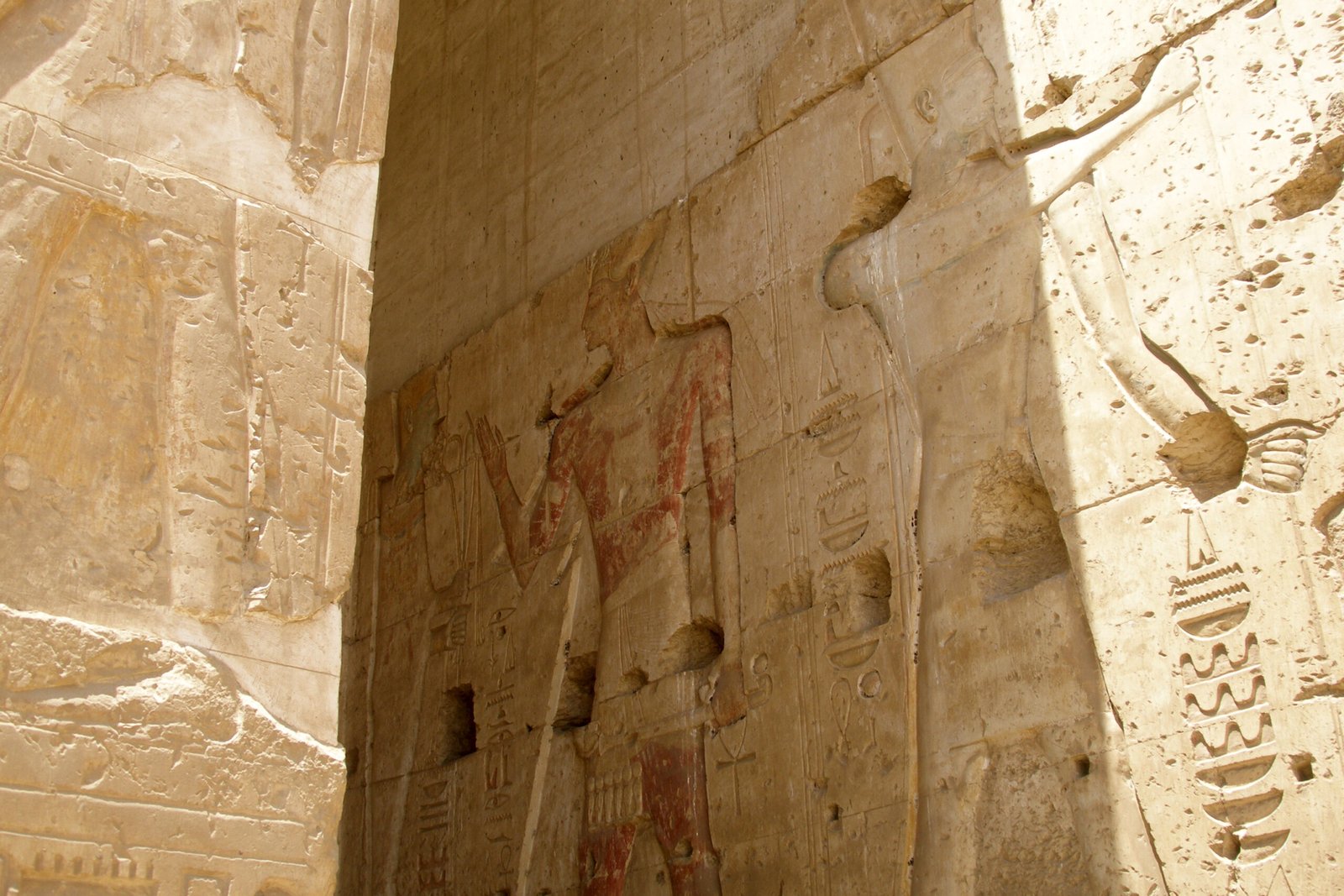 Parete di rilievi ad Abydos illuminata di taglio, con tracce di pittura rossa sulla figura regale