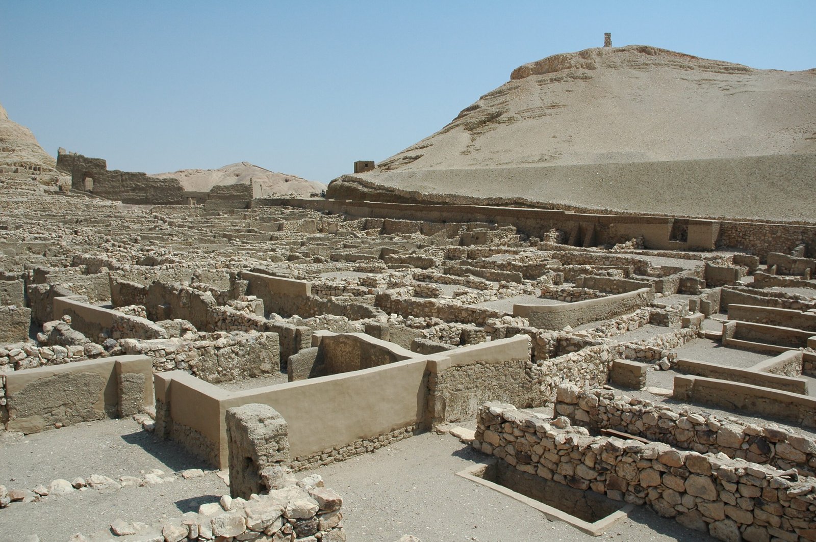 Le rovine in pietra del villaggio degli operai di Deir el Medina sotto un cielo azzurro