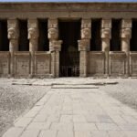 La facciata del tempio di Hathor a Dendera con le sei colonne hathoriche sotto un cielo azzurro