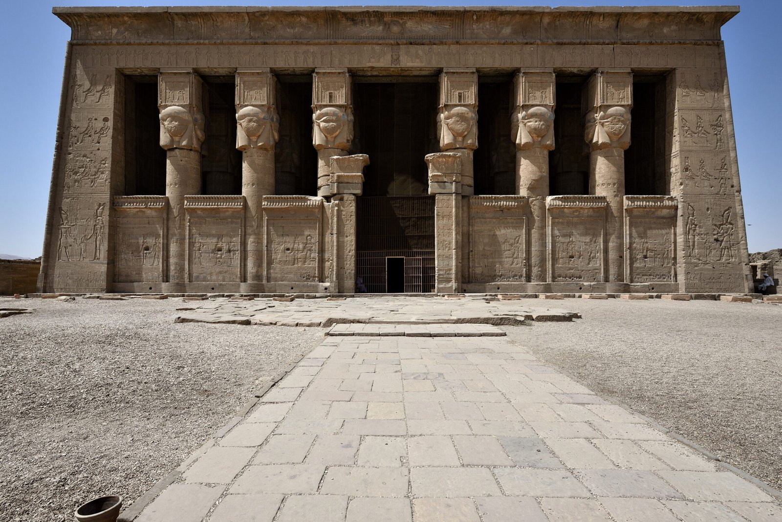 La facciata del tempio di Hathor a Dendera con le sei colonne hathoriche sotto un cielo azzurro