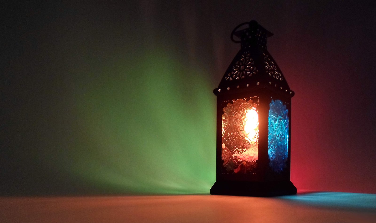 Fanous di Ramadan acceso che proietta luci colorate sulla parete
