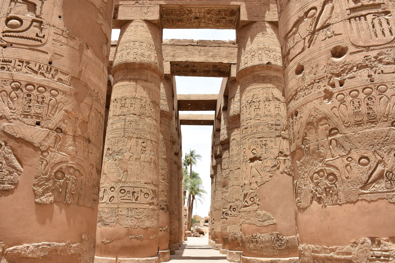 Navata laterale della sala ipostila di Karnak tra colonne papiriformi verso le palme