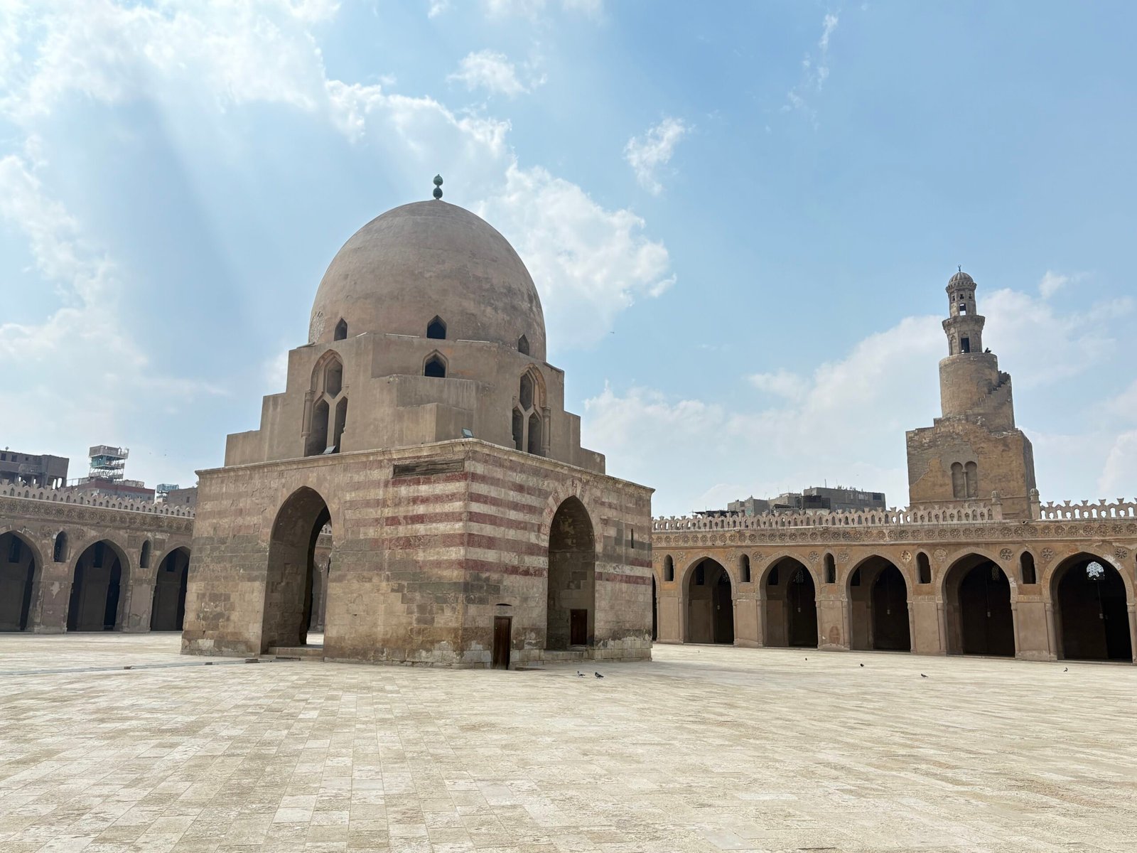 Cortile deserto della moschea di Ibn Tulun con la fontana delle abluzioni e il minareto