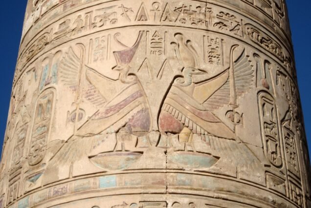 Fusto di colonna del tempio di Kom Ombo con rilievi dipinti e cielo azzurro alle spalle