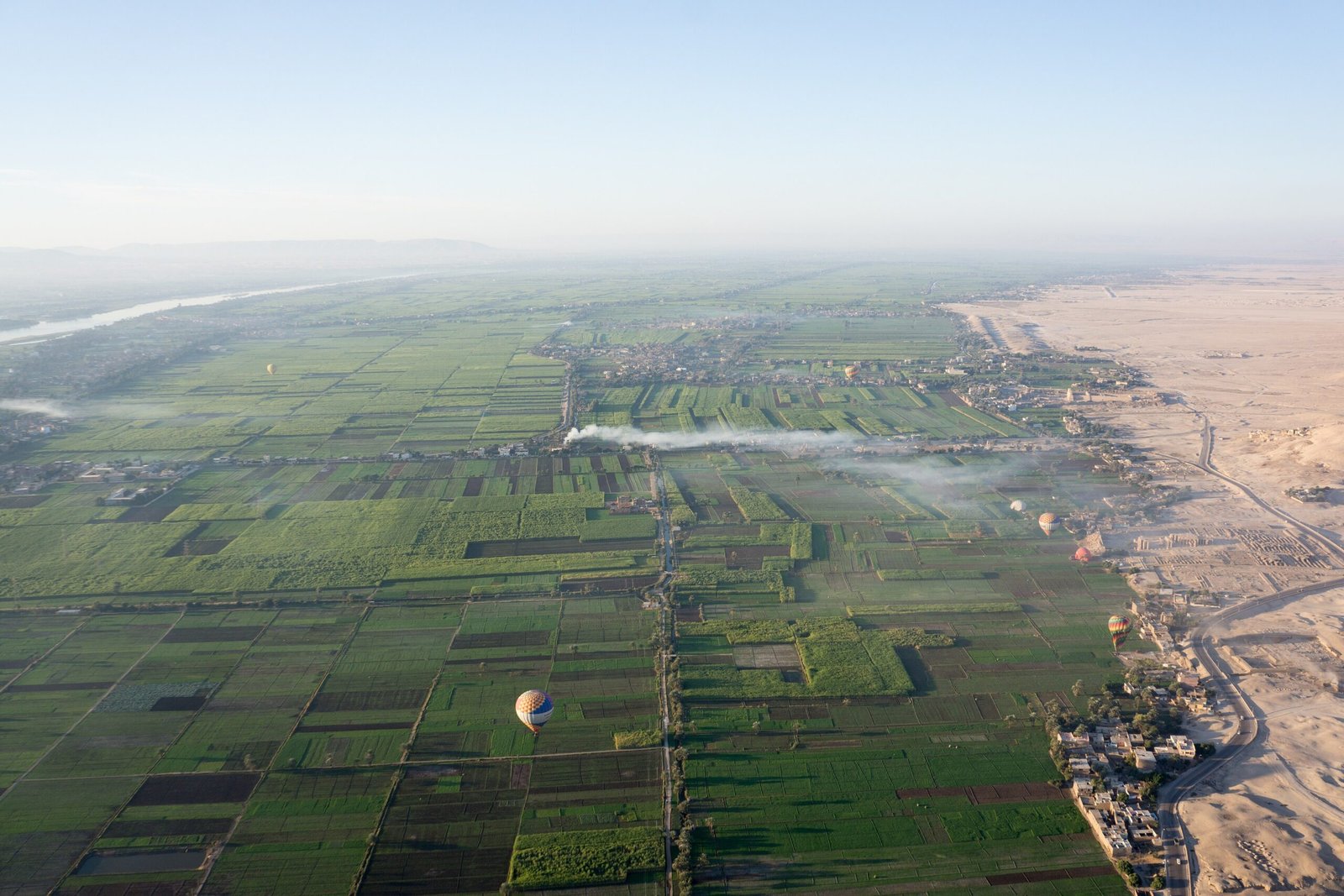Veduta aerea della valle del Nilo con campi verdi, palloni aerostatici e il limite del deserto