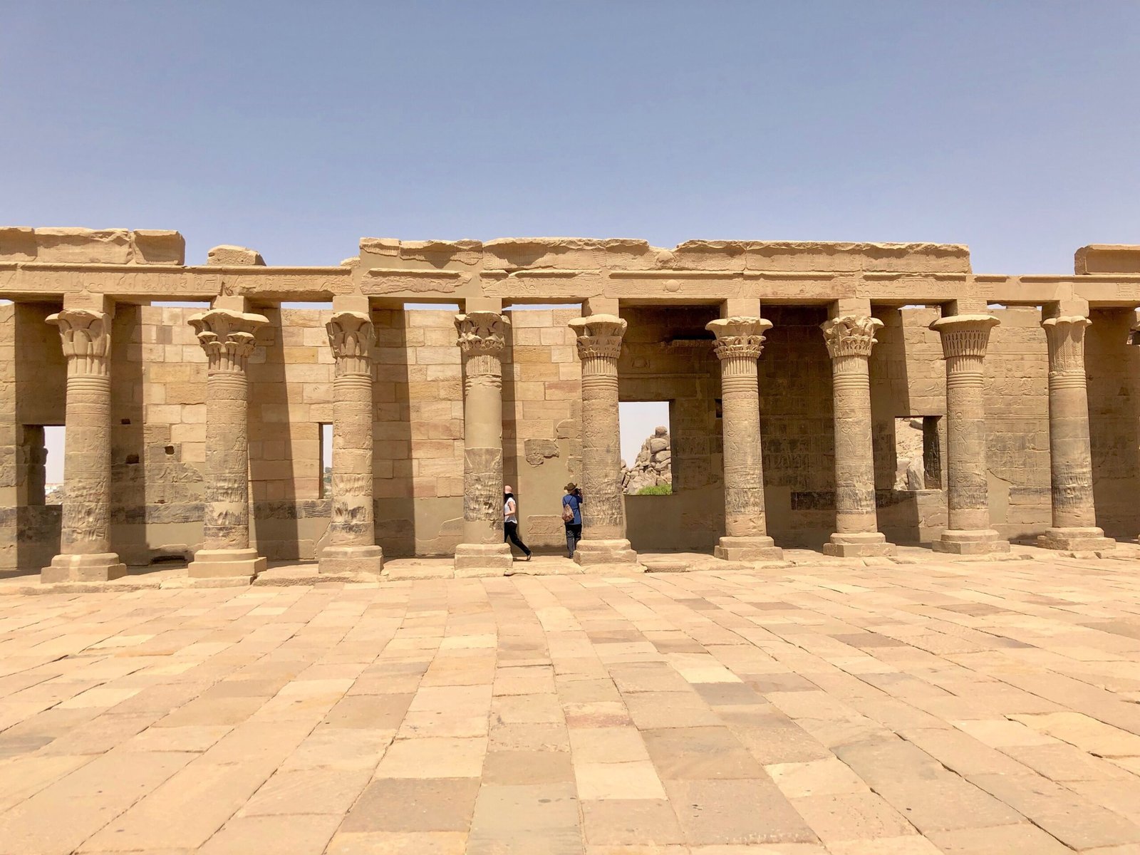 Il cortile lastricato del tempio di Iside sull'isola di File con il lungo colonnato sotto un cielo limpido