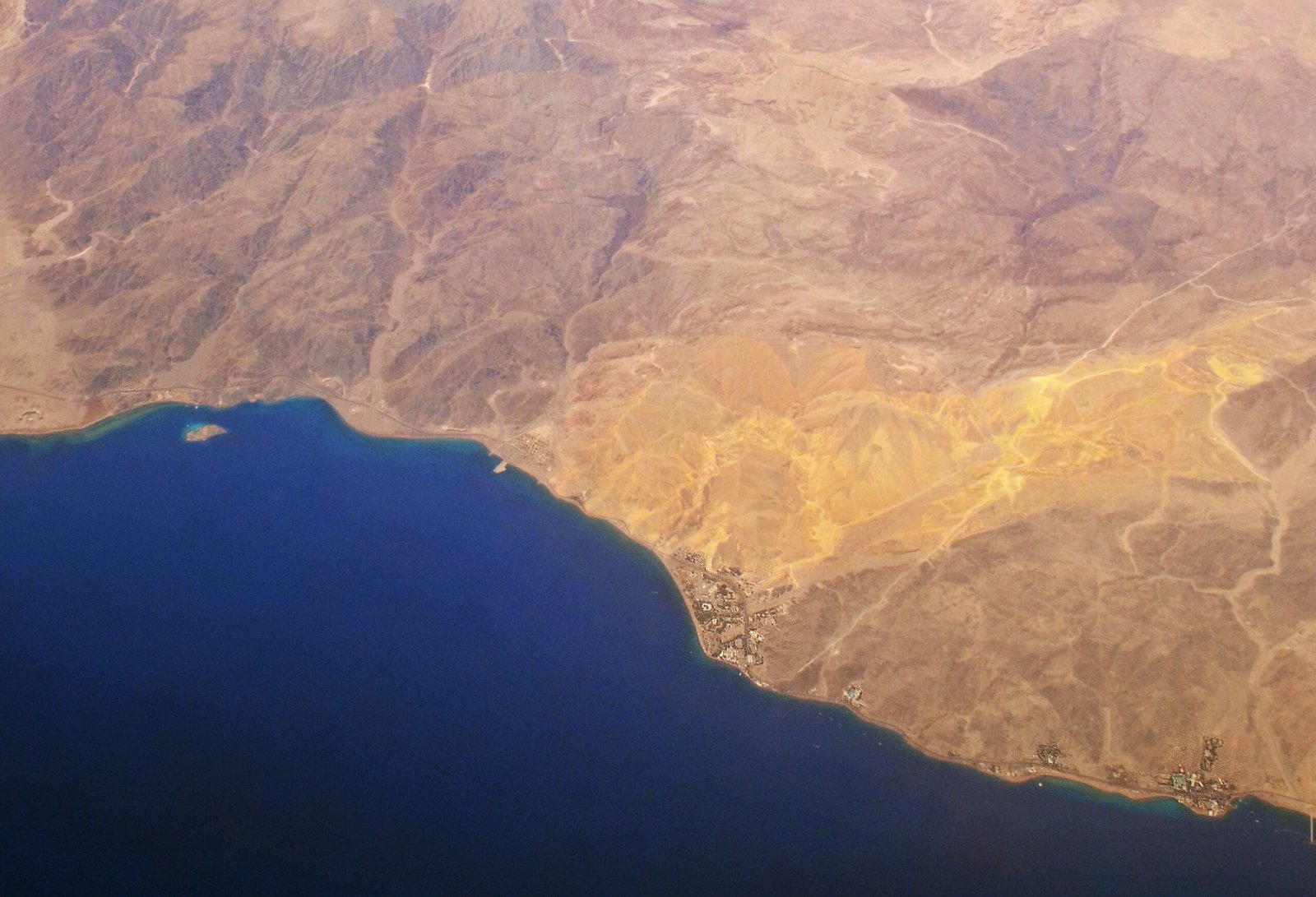 Veduta aerea della costa di Taba, con isolotto corallino, mare blu del golfo di Aqaba e montagne del Sinai