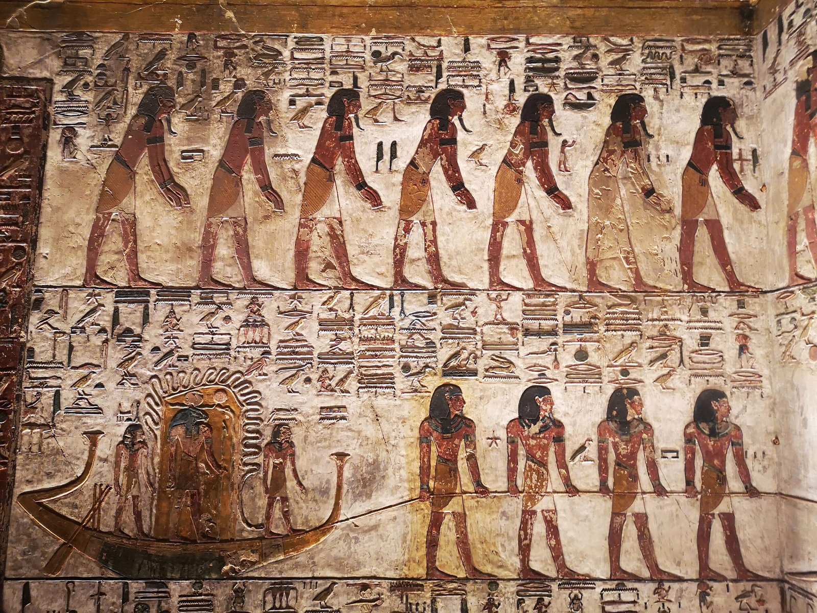 Rilievo dipinto del Libro delle Porte nella tomba di Seti I con figure in processione su fondo chiaro