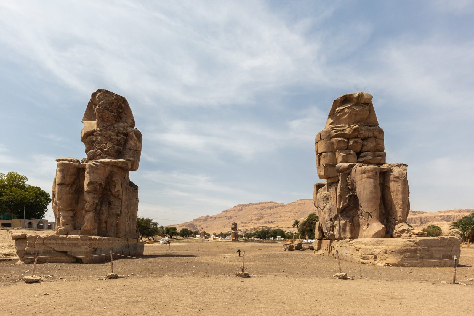I due Colossi di Memnone seduti sulla riva occidentale di Luxor con le colline tebane sullo sfondo