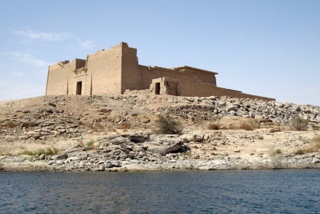 Il pilone del tempio di Kalabsha sull'isola rocciosa visto dalle acque del lago Nasser
