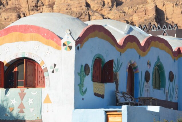 Case nubiane dipinte a Gharb Soheil con cupole bianche e finestre ad arco sotto la rupe