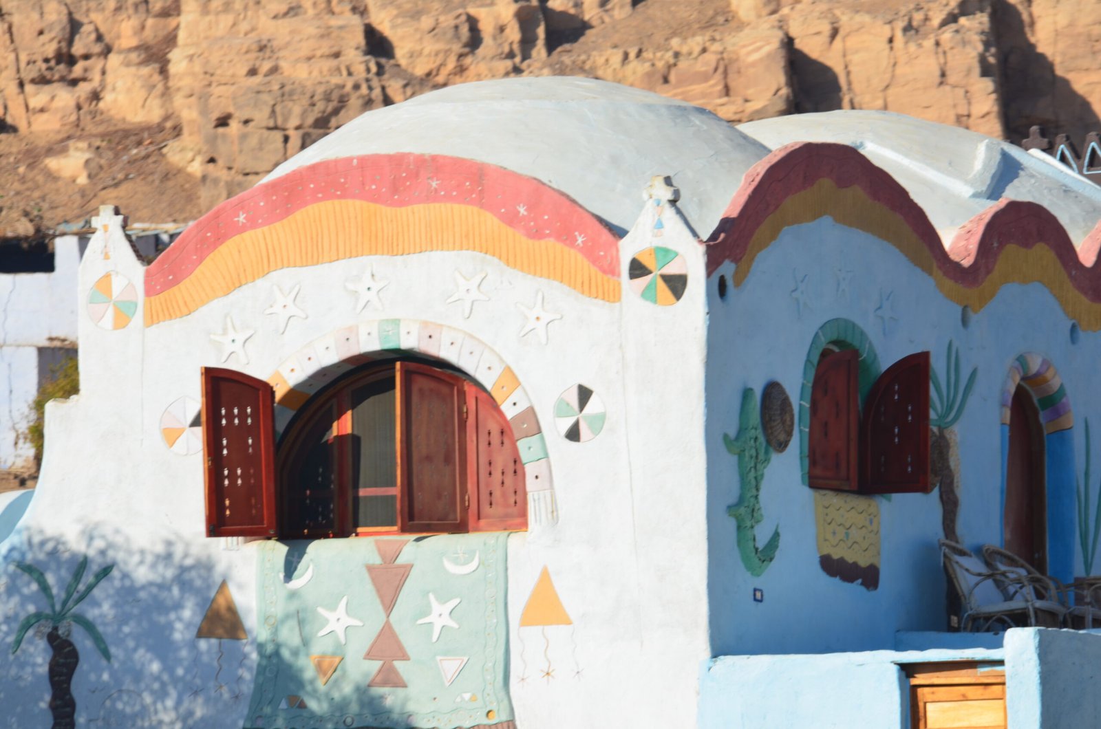 La facciata dipinta di una casa nubiana a Gharb Seheil, con le decorazioni geometriche e le finestre azzurre