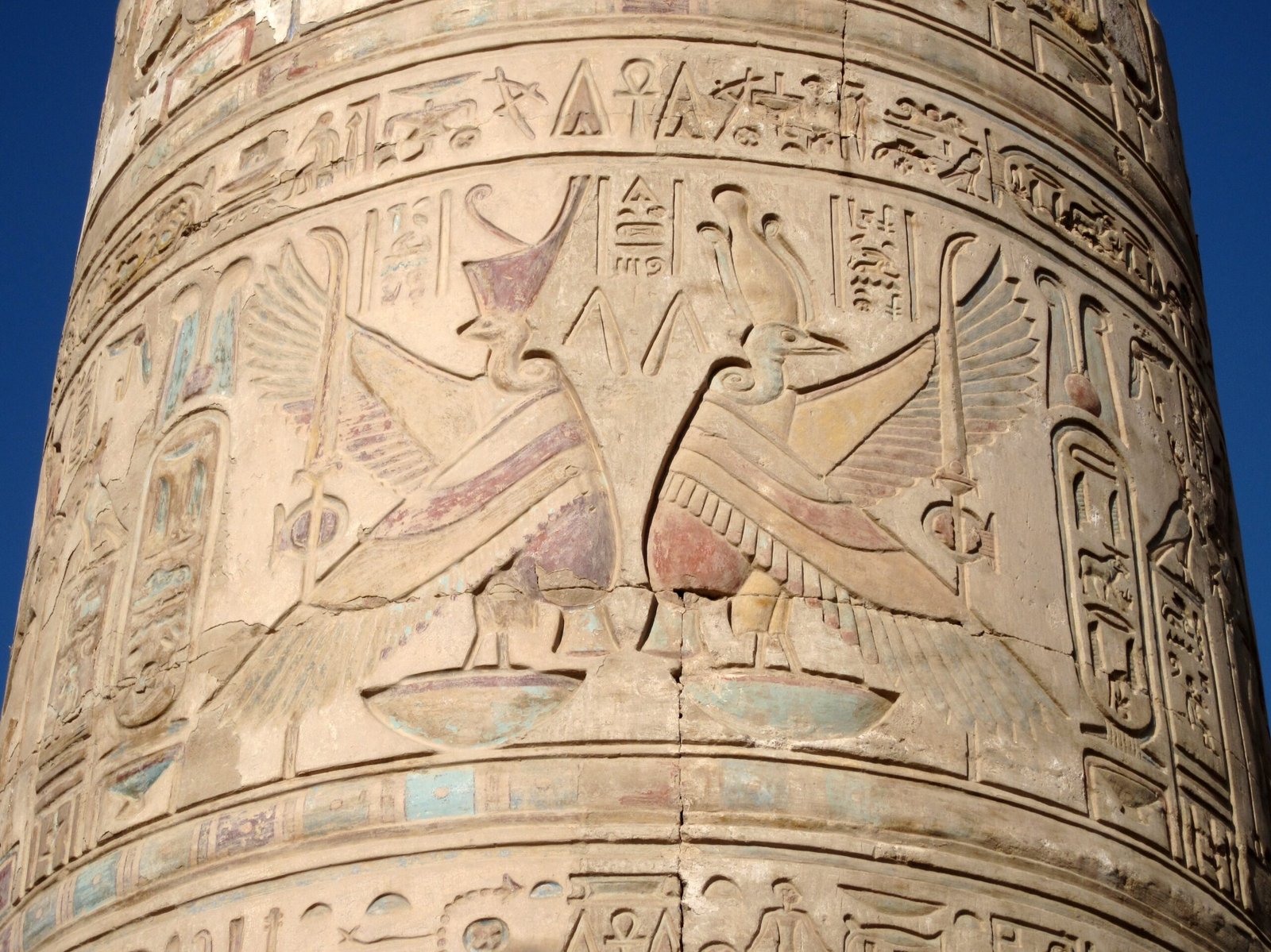 Rilievi dipinti su una colonna del tempio di Kom Ombo contro il cielo azzurro