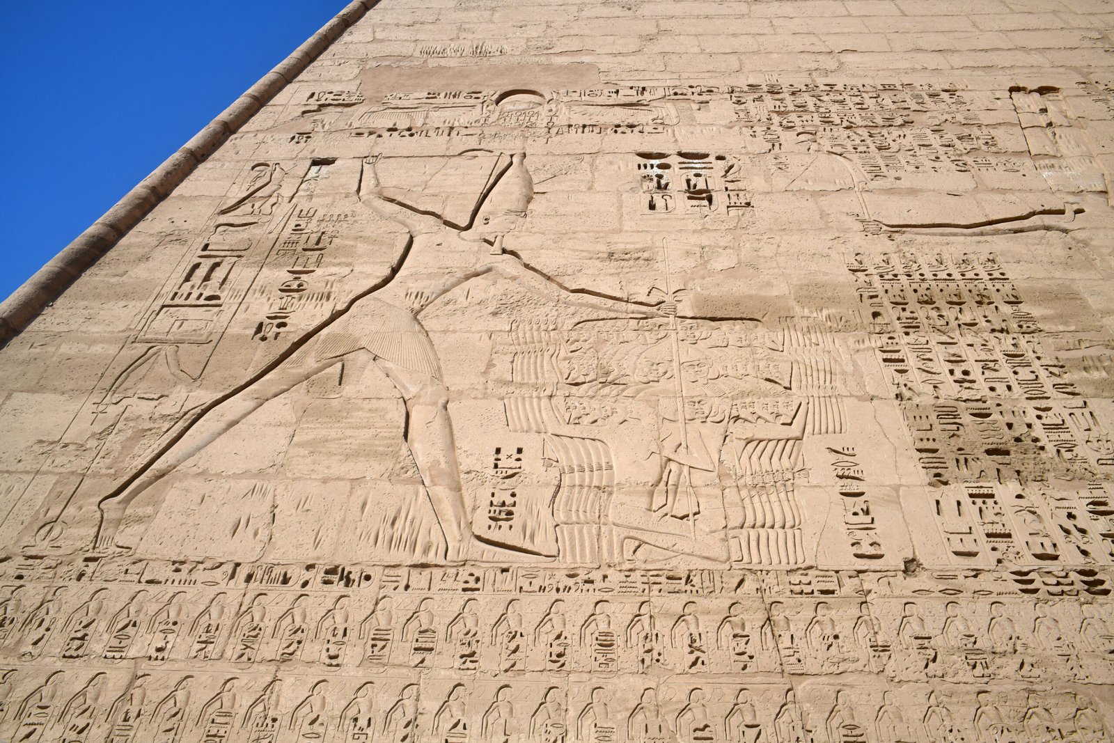 Il primo pilone di Medinet Habu con i grandi rilievi scolpiti contro il cielo azzurro