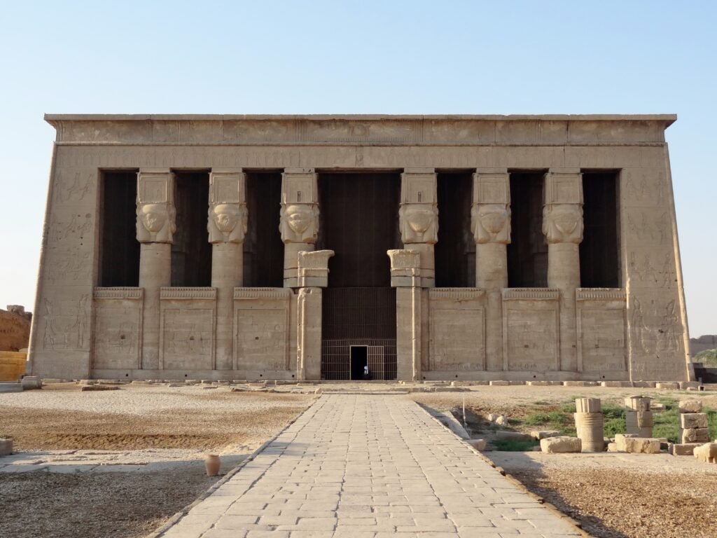 La facciata colonnata del tempio di Hathor a Dendera, con i capitelli a volto di dea, vista dal viale di accesso
