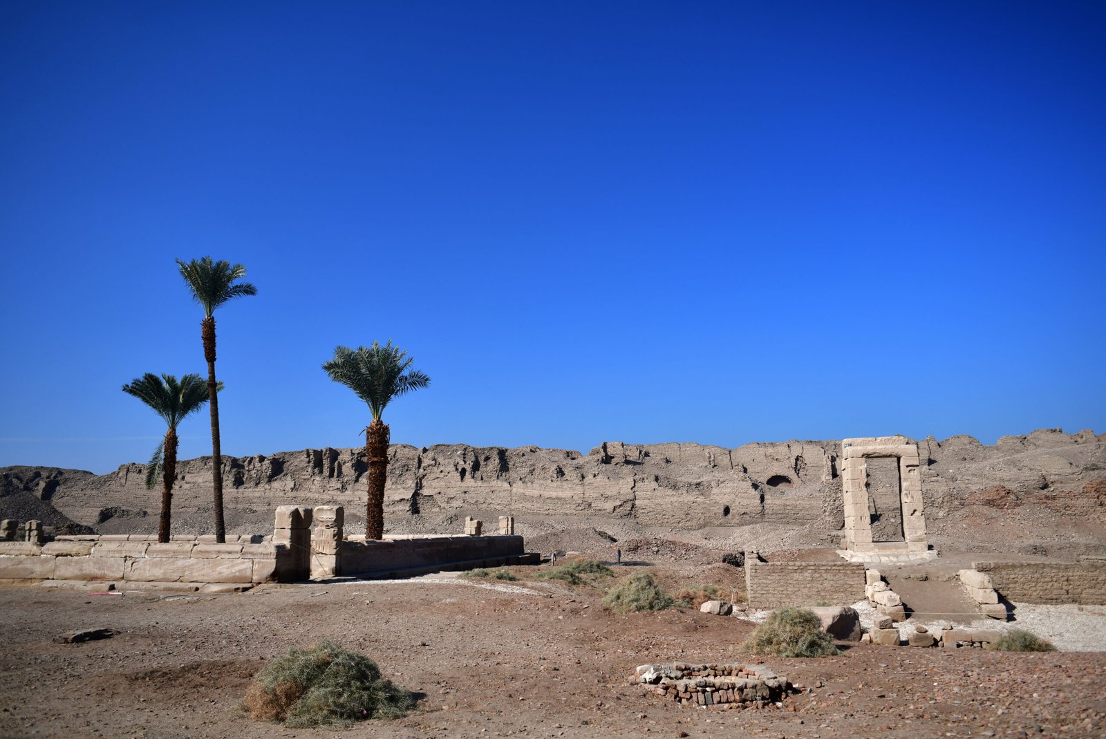 Il muro di cinta in mattoni crudi del tempio di Dendera tra la macchia del deserto