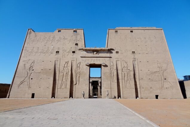 Il grande pilone del Tempio di Horus a Edfu visto da lontano sotto il cielo azzurro