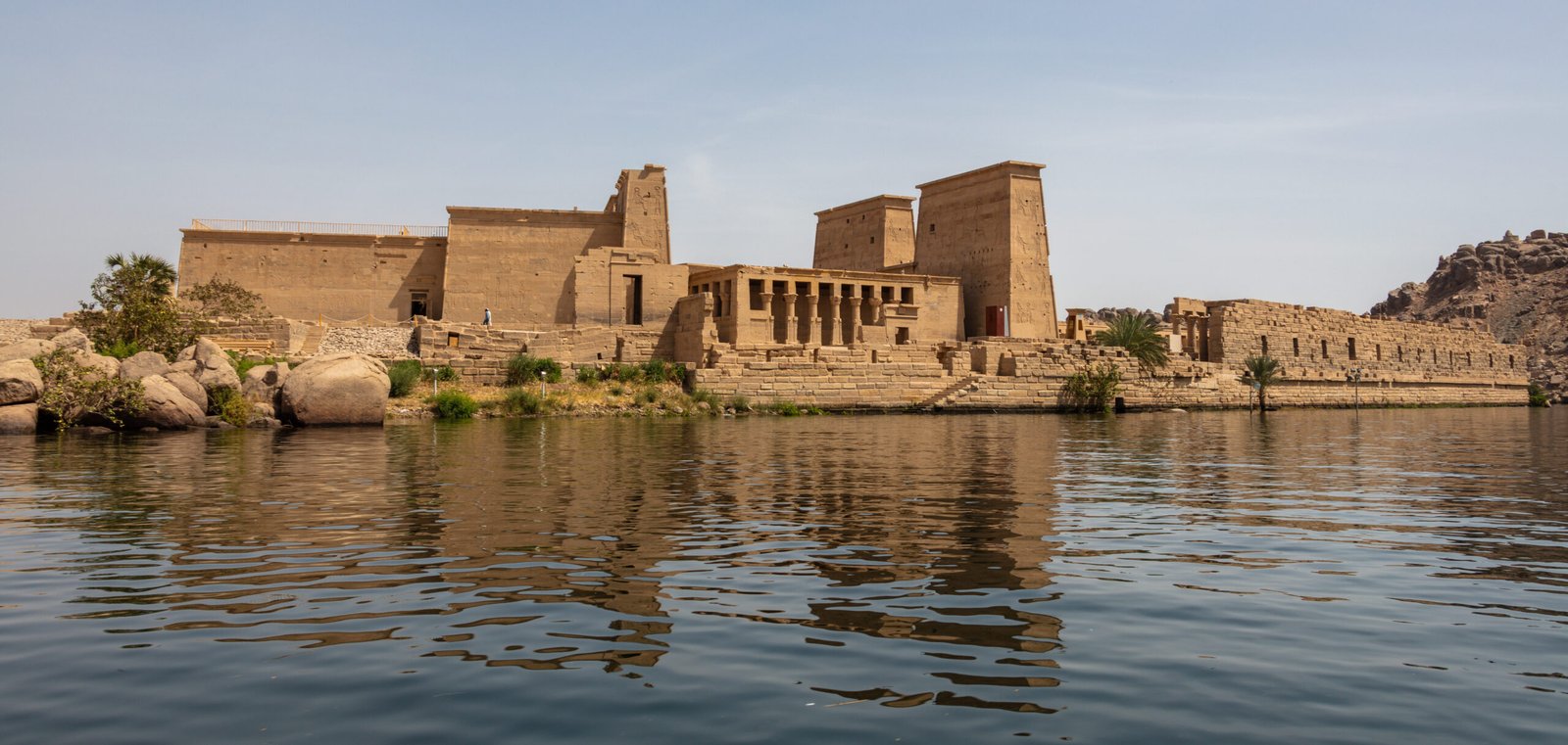 Il tempio di Philae visto dall'acqua, con i piloni e il colonnato che si riflettono nel Nilo ad Assuan