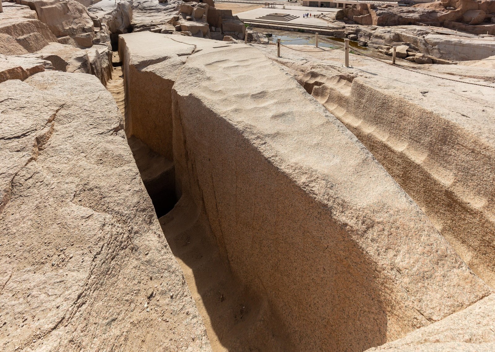 L'obelisco incompiuto nella cava di granito di Assuan, ancora attaccato alla roccia, con il canale di taglio e i segni degli strumenti sulla superficie