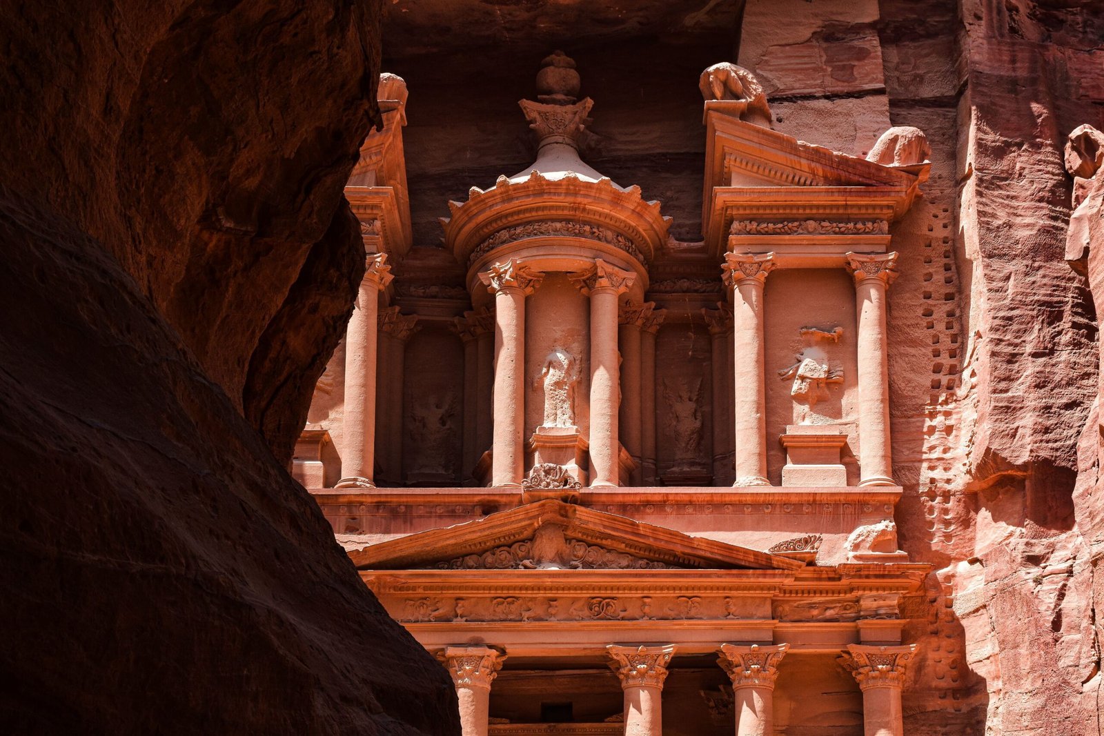 La facciata del Tesoro di Petra, al-Khazneh, scolpita nella roccia rosa e vista dal Siq