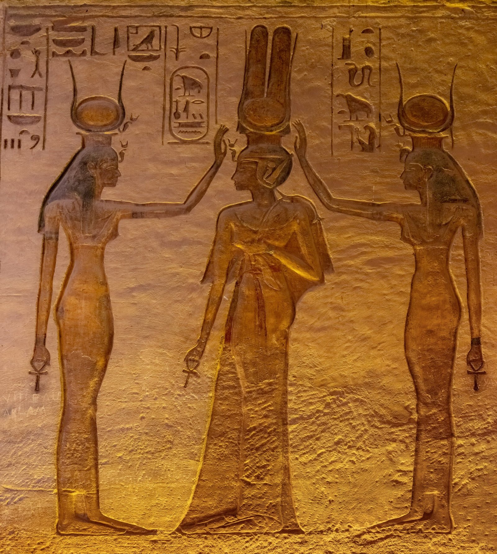 Un rilievo dorato nel tempio di Nefertari con la regina tra le dee Hathor e Iside