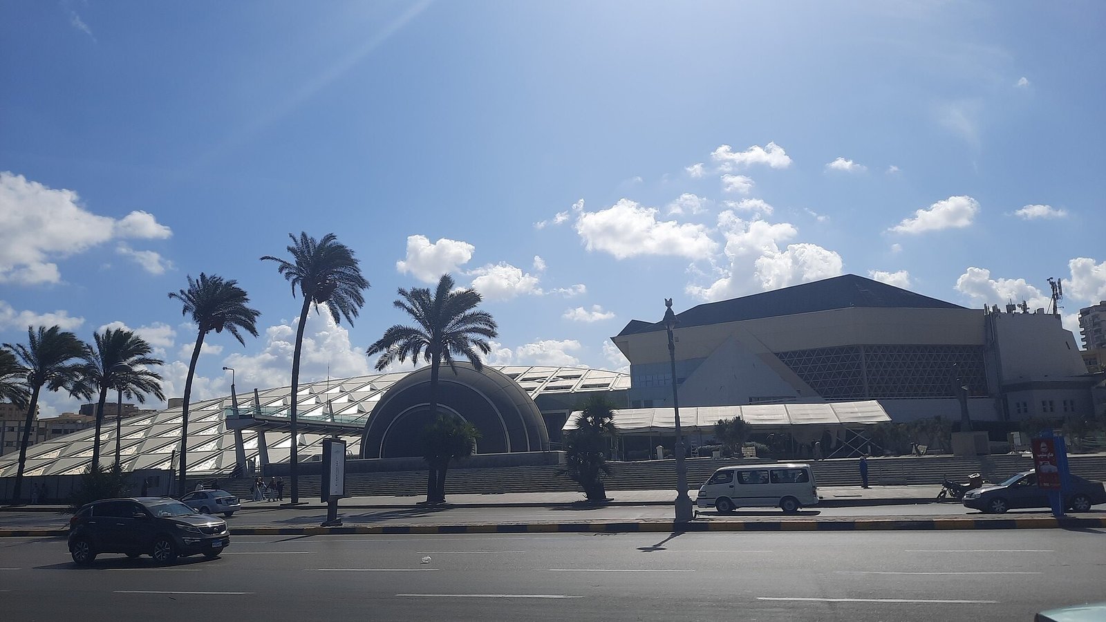La Biblioteca di Alessandria vista dalla strada, con le palme e la cupola del planetario in primo piano