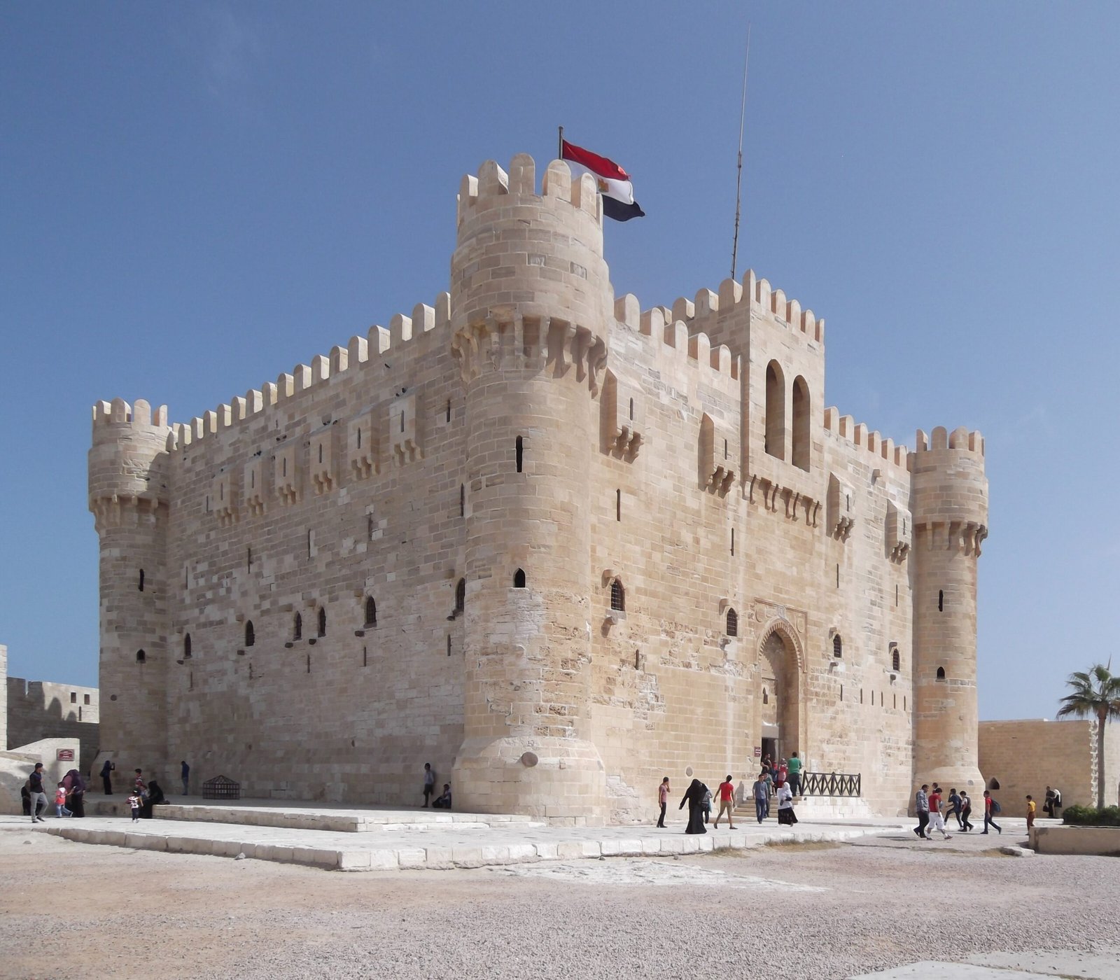 La cittadella di Qaitbay ad Alessandria, con le torri merlate di pietra chiara e la bandiera egiziana