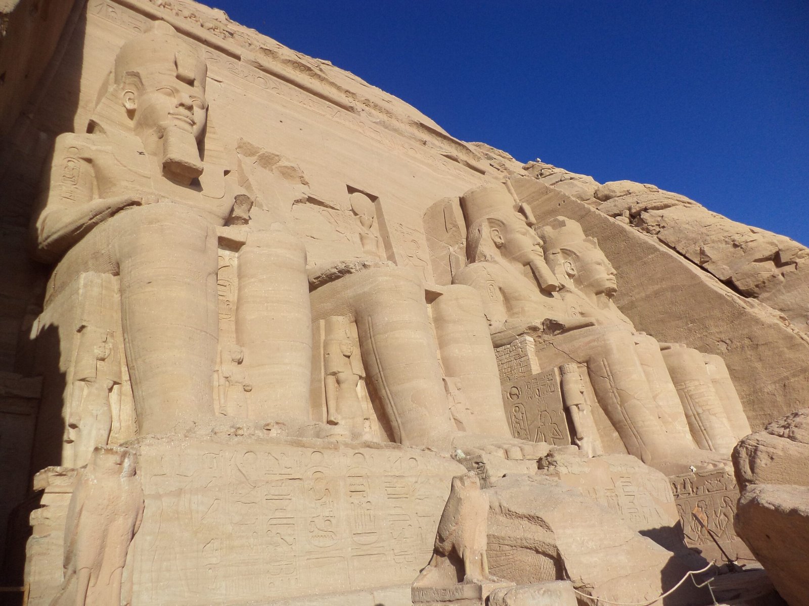 I colossi di Ramses II sulla facciata del Grande Tempio di Abu Simbel, visti di sbieco sotto il cielo blu